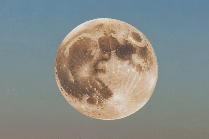 Der Mond am Abendhimmel über einer Landschaft — Beitragsbild zu „Einen Mondkalender lesen: Zeichen, Zeiten und Fallstricke“